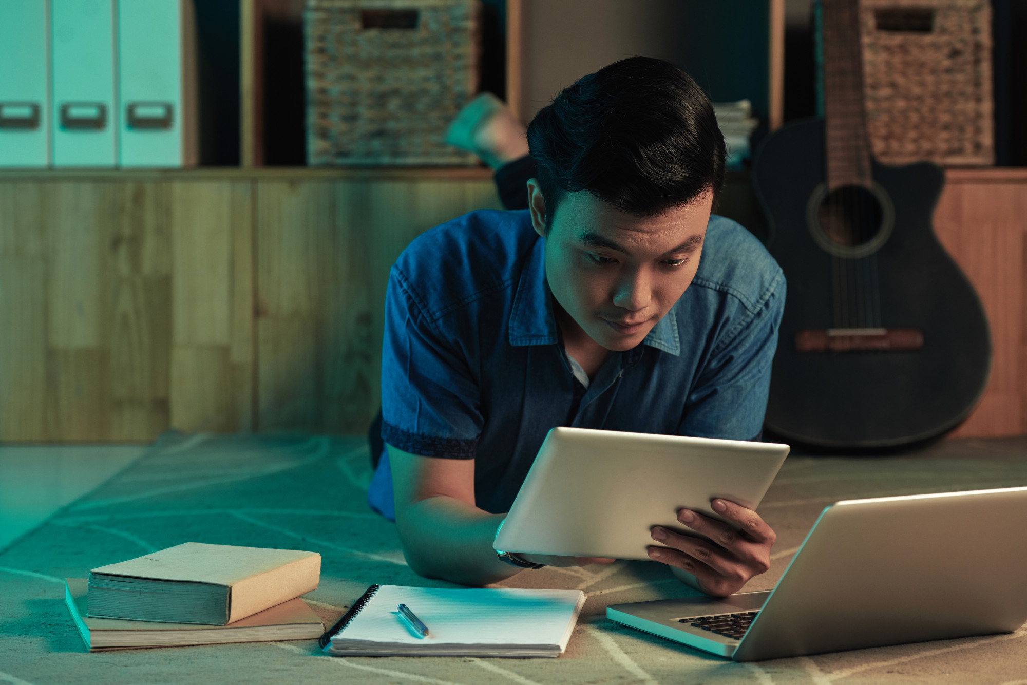 Young man focused on studying at a desk with books and notebooks, likely preparing for an exam.